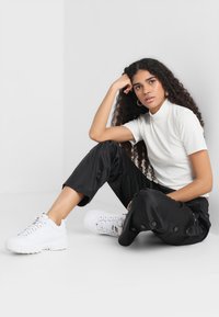 Fila GERALYN BUTTON PANTS - Pantalon de survêtement - black