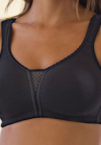 Black bra with a soft texture, featuring a lace insert at the center and scalloped edges along the neckline and shoulder straps.