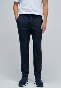 Pantalones deportivos de color navy fabricados con una tela ligera y suave, con una cintura elástica y cordón. Cuentan con piernas ajustadas y bolsillos laterales.