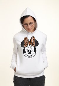 Sudadera blanca con un gráfico de la cara de un personaje de dibujos animados. El personaje tiene un gran lazo de estampado de leopardo y orejas negras. Tela suave, con cordones.