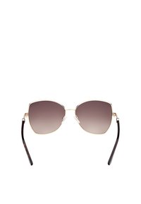 Occhiali da sole cat-eye color oro con lenti scure sfumate, tamponi nasali trasparenti e bracci in tartaruga nera. Texture liscia e forma geometrica.