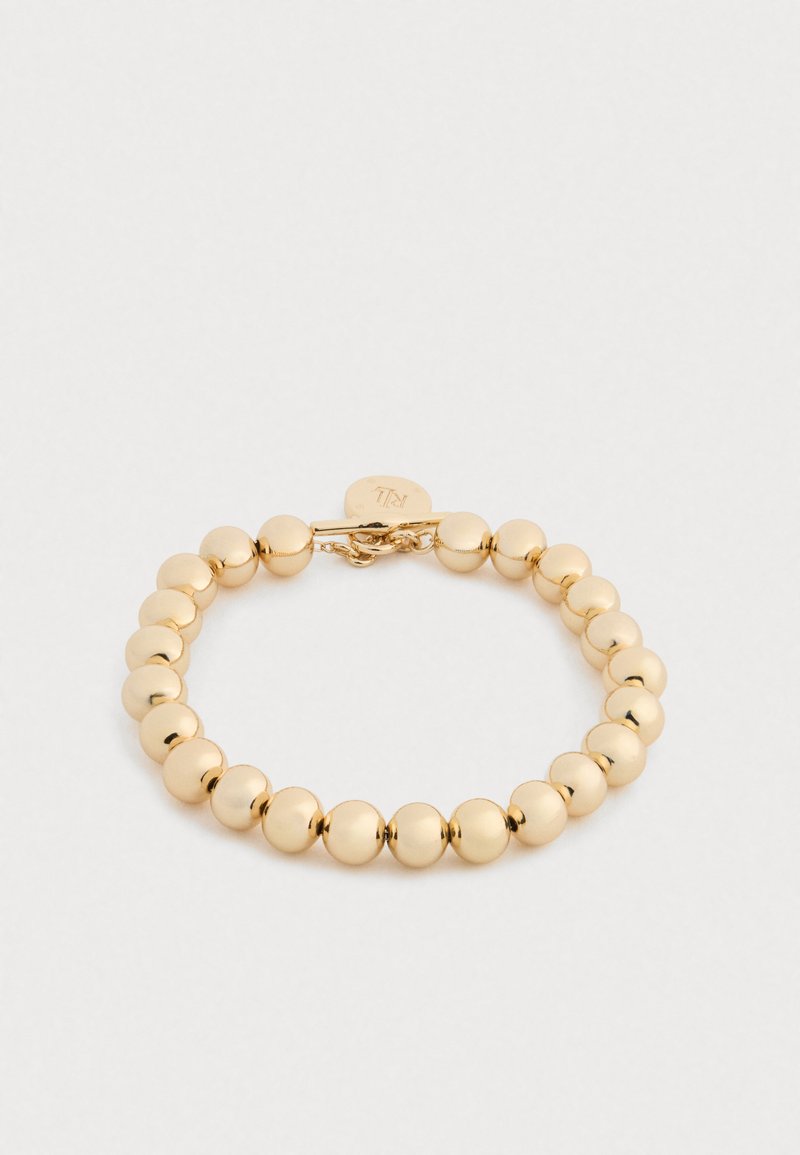 Pulseira de contas douradas com contas esféricas brilhantes, segura com um fecho de metal. Design simples com uma textura suave.