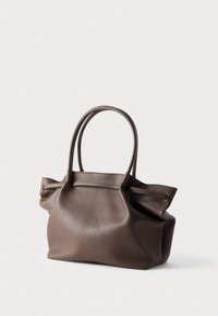 Καφέ δερμάτινη τσάντα ώμου με υφή στην επιφάνεια, δύο λαβές και μαλακό, χαλαρό σχήμα. Μινιμαλιστικός σχεδιασμός χωρίς ορατά μεταλλικά στοιχεία ή σχέδια.