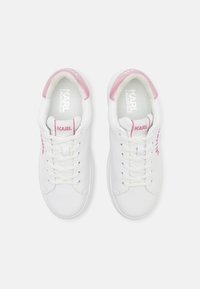 Bele tenisice z roza detajli. Imajo gladek material, okroglo špico, ravne vezalke in logotip blagovne znamke na straneh ter notranjosti.