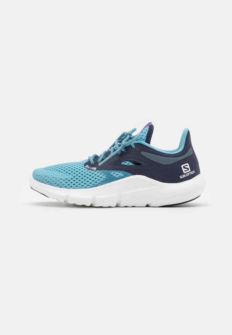 Chaussure de sport en mesh bleu clair avec des accents bleu foncé, une semelle blanche et un détail violet au talon. Dispose d'une fermeture à lacets et d'un design respirant.