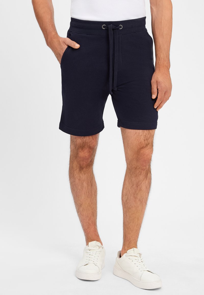 Navy cotton blend shorts with an elastic waistband and adjustable drawstring, featuring side pockets and a rolled hem.