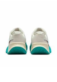 Zapatillas deportivas de malla blanca con un acabado texturizado, suela turquesa y sutilezas en color marrón. Cuentan con un talón acolchado y detalles del logo.