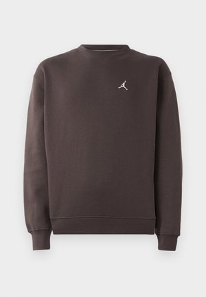 Tmavohnedá mikina s dlhým rukávom a okrúhlym výstrihom, s malým bielym logom Jumpman na ľavej hrudi, rebrovanými manžetami a spodným lemom.