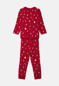 Conjunto de pijama rojo con mangas largas y pantalones. Presenta estampados coloridos con temática navideña, incluyendo árboles, regalos y adornos. Textura de tejido suave.