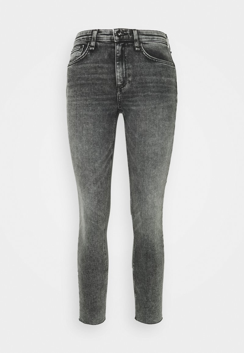 Jeans skinny negros deslavados con una cintura de altura media, diseño de cinco bolsillos y cierre de botón metálico. Textura de denim suave, pierna de corte ajustado.