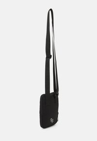 Borsa a spalla nera con tracolla regolabile, forma rettangolare, texture morbida, con chiusura a zip e dettaglio del logo sul fronte.