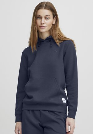 Navy hoodie with drawstrings, kangaroo pocket, ribbed cuffs, and waistband; soft texture, featuring a small logo patch.
