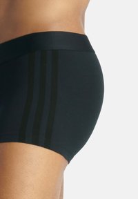 Svart boxershorts med en slät textur, med tre vertikala mörka ränder på sidan. Elastisk midjeband med en tät passform.