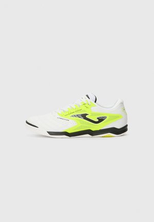 Hvit sportssko med neongule detaljer, svart såle, teksturert overdel, perforeringer for ventilasjon og kontrasterende lisser.