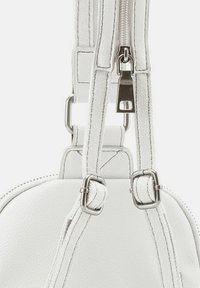 Borsa a mano bianca in pelle caratterizzata da una superficie testurizzata, design elegante, accessori in metallo, doppi manici e una chiusura con zip prominente.