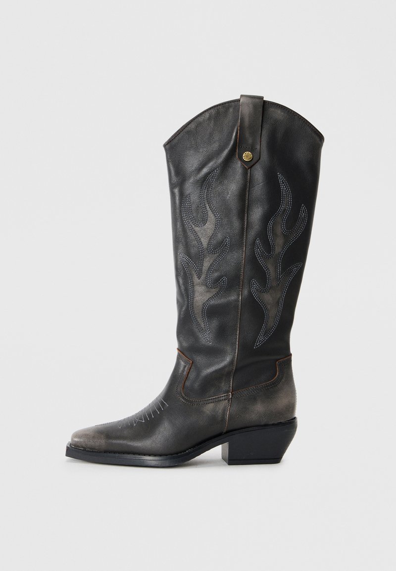 Black leather cowboy boot with flame-like stitching, pointed toe, and a low block heel. Features a decorative metallic button on the side.