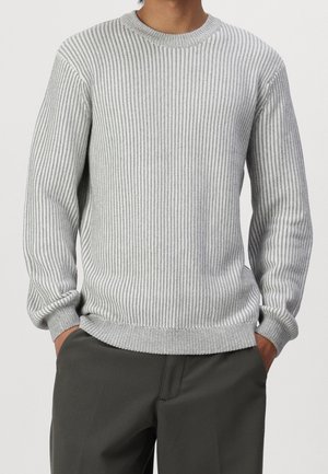 Hellgrauer, gerippter Strickpullover mit langen Ärmeln, Rundhalsausschnitt und strukturiertem Stoff, kombiniert mit dunklen Hosen. Hat eine lässige Passform.