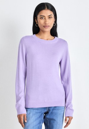 Maglione a maniche lunghe di colore viola chiaro, con colletto rotondo, polsini e orlo a costine; taglio slim con dettagli a spacco laterale. Abbinato a jeans blu.