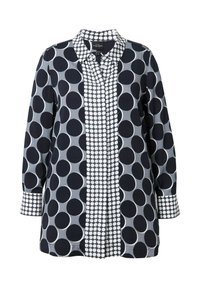 Chemise à manches longues avec un mélange de grands pois noirs et blancs, dotée d'une patte de boutonnage à motif, fabriquée dans un tissu lisse aux tons marine et gris.