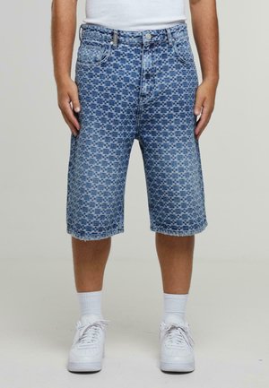 Denim shorts in a blue checkered pattern, featuring a high waist, regular fit, and frayed hem. Paired with white sneakers and socks.