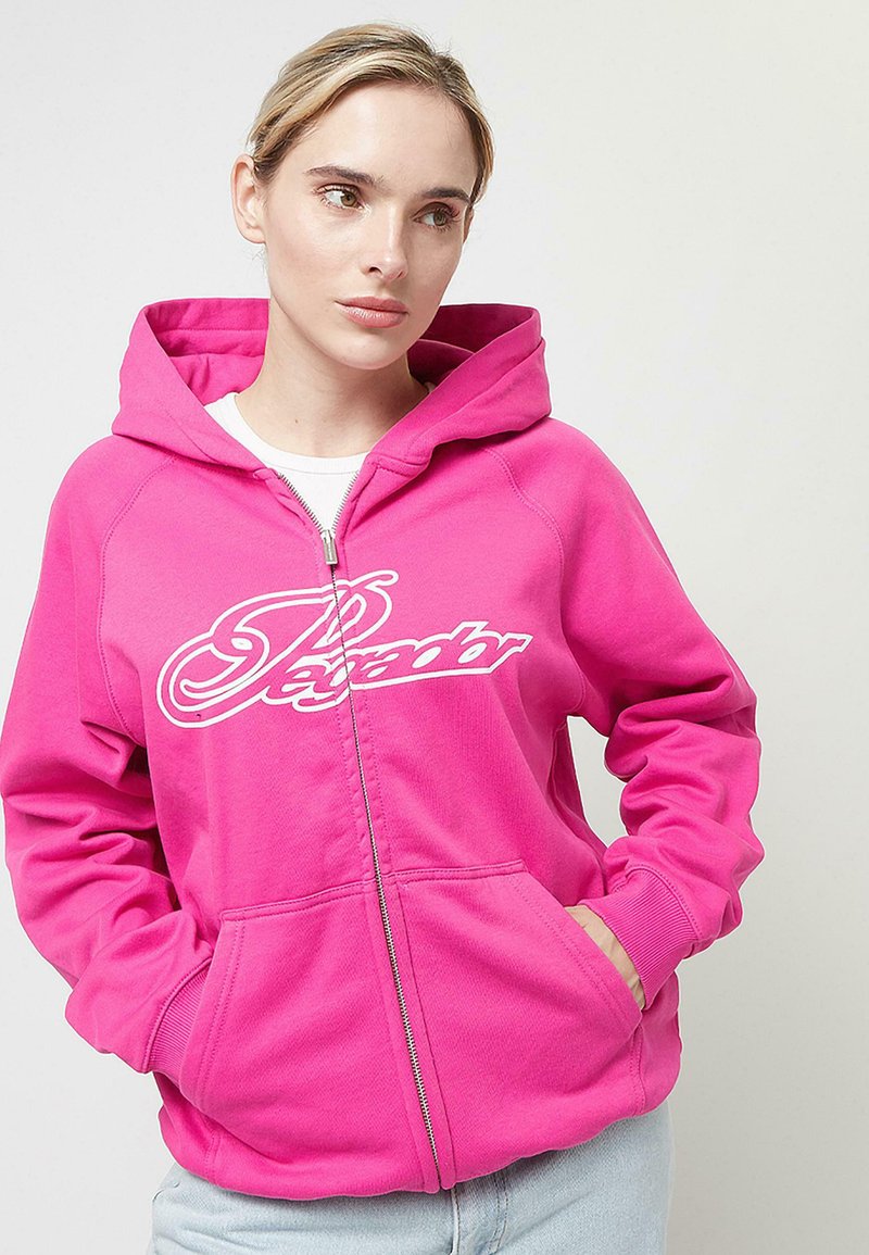 Sudadera con cremallera en rosa brillante, con un diseño de logo blanco en el pecho. Tiene capucha y bolsillos frontales, hecha de un tejido suave.