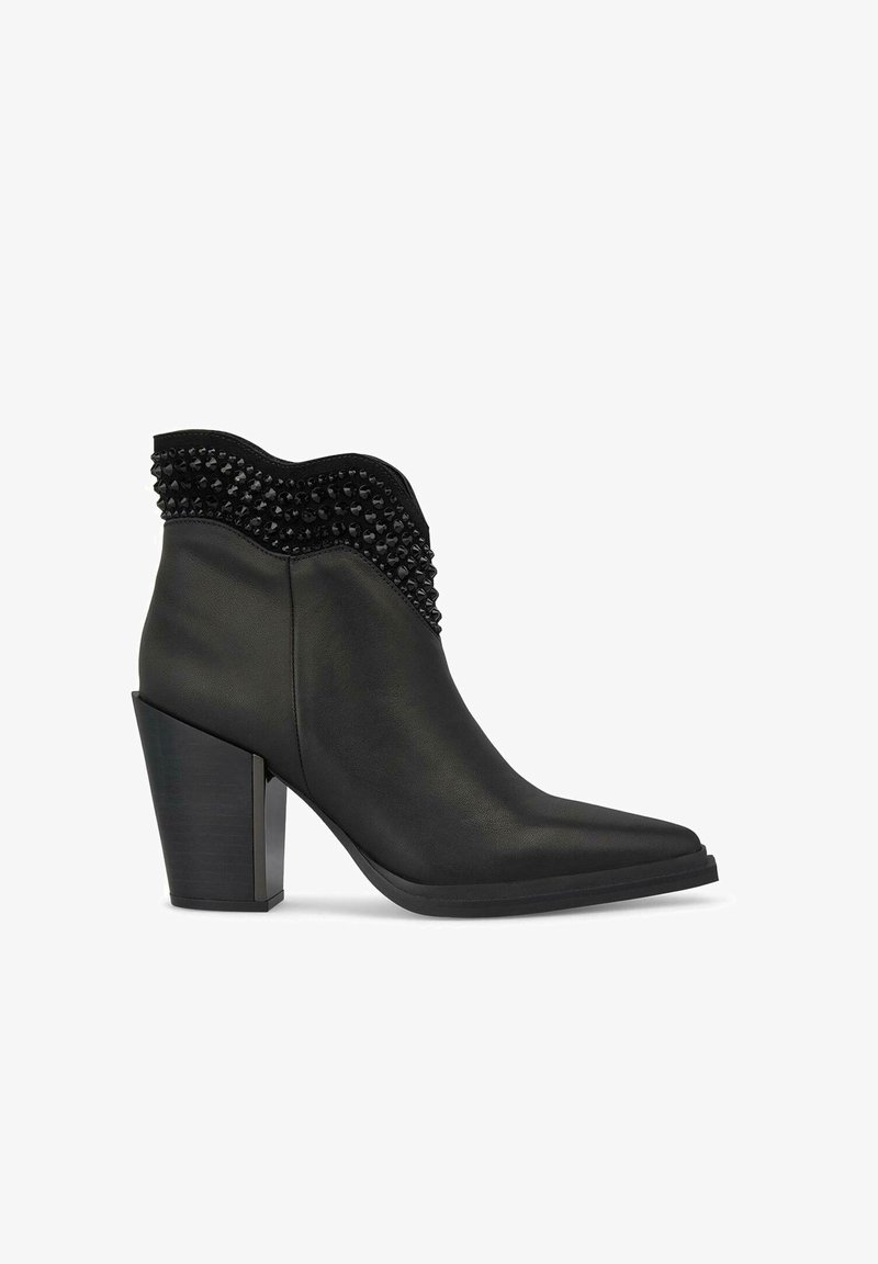 Czarne skórzane botki za kostkę z ostrym noskiem, teksturowanym, falistym kołnierzem i ćwiekowanymi akcentami. Gruba, blokowa szpilka dla dodatkowego wzrostu.