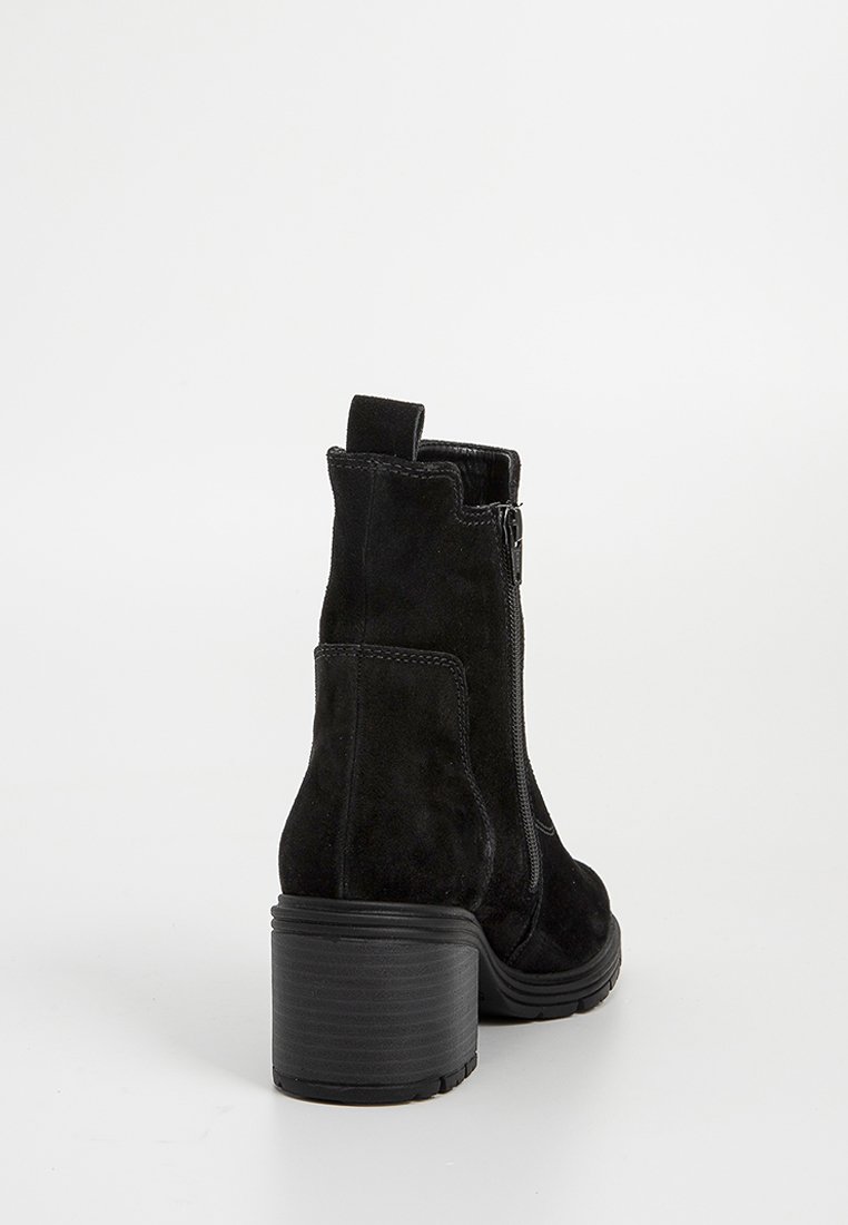 Zwarte suède enkellaarsjes met een ronde neus, zijrits en een brede blokhak. Het ontwerp kenmerkt zich door minimale stitching en een gestructureerde afwerking.