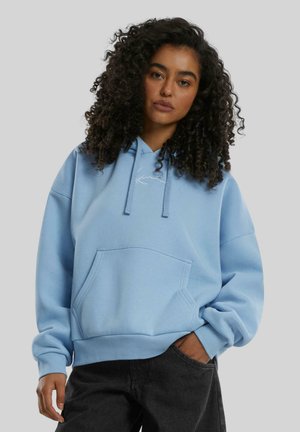 Helle blaue Baumwoll-Hoodie mit einer Kängurutasche, verstellbaren Kordeln und gerippten Bündchen an Ärmeln und Saum. Einfaches Logo-Detail auf der Brust.