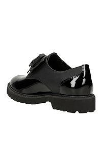 Zwarte gepatineerde lederen schoen met een ronde neus, dikke rubberen zool en een decoratieve strikaccent aan de zijkant. Gladde textuur met een glanzende afwerking.