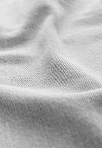 Hellgrauer Stoff mit einer glatten, strukturierten Oberfläche, die feine, diagonale Webmuster und einen weichen Fall zeigt. Ideal für Bekleidung oder Polsterungen.