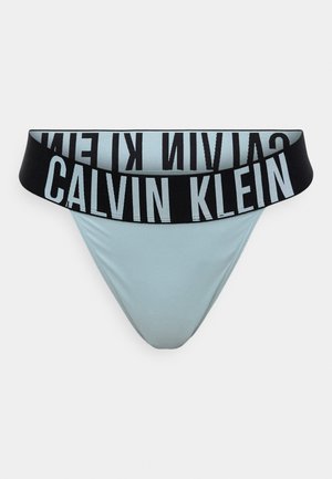 Világoskék tanga fekete rugalmas derékrésszel, amelyen világoskék színnel van nyomtatva a "CALVIN KLEIN" felirat. Sima anyag, feszes szabású.