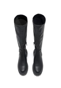 Botas negras hasta la rodilla, hechas de cuero suave, con puntera redondeada, cremalleras laterales y una suela de goma texturizada para mayor agarre.