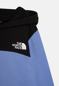 Hanorac cu glugă, având un design colorat cu panouri negre și albastre deschise. Logo-ul alb proeminent pe piept, realizat dintr-un material moale de bumbac.