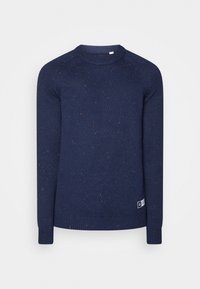 Marinblå stickad tröja med rund hals och långa ärmar, med små orangea och blå prickar samt en rektangulär vit etikett nära fållen.