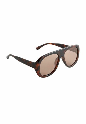 Przesadnie duże okulary przeciwsłoneczne w wzór szylkretowy z brązowymi przyciemnianymi soczewkami i grubymi, zaokrąglonymi oprawkami na białym tle.