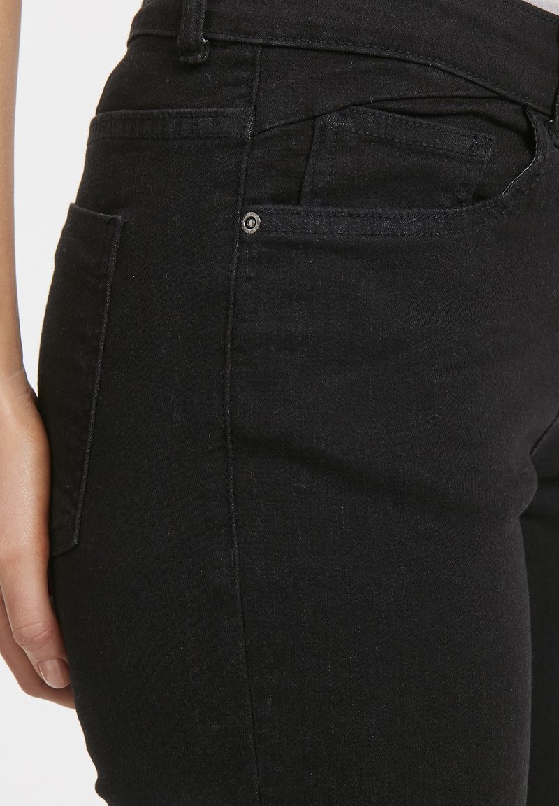 Jeans negri din denim, cu un croi slim, dotate cu un buzunar frontal, ușoară decolorare și o talie cusută pentru o rezistență suplimentară.