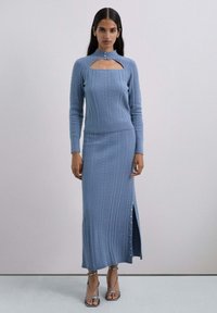 Conjunto de dos piezas de punto azul claro con textura acanalada, detalle con corte en el escote y una abertura lateral con acentos de botones.