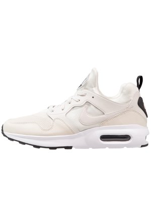 Witte Nike Air Max sneaker met zwarte zool, zichtbare luchtkussen in de hiel, veters aan de voorkant en zwarte trekband aan de achterkant.