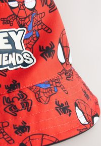 Cappello a secchiello rosso con motivi di Spider-Man e ragnatele, con bordo cucito e etichetta logo. Realizzato in tessuto resistente e leggero.