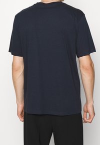 Marineblå bomulds T-shirt med korte ærmer. Løs pasform, rund halsudskæring og glat tekstur. Ingen synlige mønstre eller grafik.