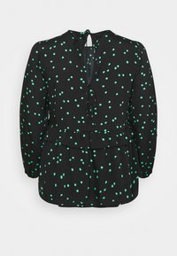 Schwarze Bluse mit grünen Punkten, mit langen Ärmeln, einem Peplum-Saum und einem Schlüsselloch-Rücken mit Schleifenverschluss. Glatte Stoffstruktur.