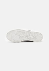 White rubber sneaker sole featuring textured surface, zigzag tread pattern, and embossed branding. Clean design with minimal detailing.