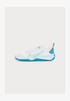 Weißer und türkisfarbener Nike-Sneaker mit perforiertem seitlichem Swoosh, türkisfarbiger Sohle, roter Naht an der Ferse und Schnürdesign auf neutralem Hintergrund.