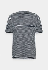Camiseta de manga corta a rayas blancas y negras exhibida sobre un fondo blanco, mostrando su patrón y diseño únicos.