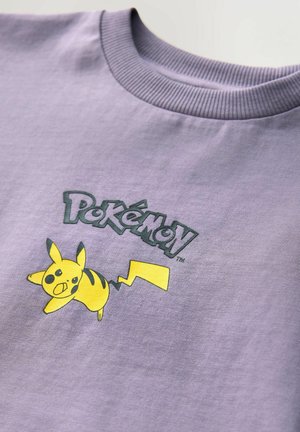 T-shirt di cotone viola con grafica di Pikachu gialla e testo "Pokémon", dotato di collo a compressione a coste e texture liscia.