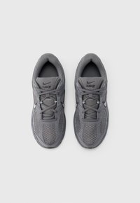 Αθλητικά παπούτσια Nike σε σκούρο γκρι χρώμα, με επάνω μέρος από δίχτυ,  επενδεδυμένο κολάρο και κλείσιμο με κορδόνια. Οι υφασμένες σόλες προσφέρουν κράτημα και πρόσφυση.