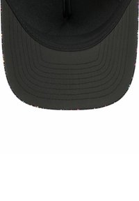 Casquette noire à visière plate, avec une surface texturée et un motif coloré et tacheté le long du bord. Il y a un trou de ventilation central.
