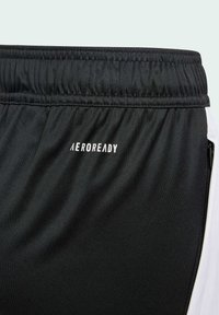 Svarta idrottsshorts med elastiskt midjeband, slät textur, reflekterande "AEROREADY"-logotyp och en vit accent på sidan.