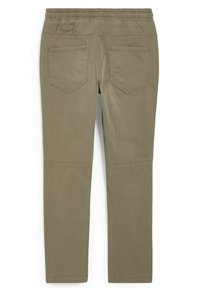 Pantalon kaki à taille élastique avec deux poches arrière et détails de coutures au niveau des genoux, vu de dos.