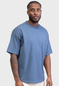 Men's blue short-sleeve t-shirt made of cotton, featuring a round neckline and a chest pocket. Shirt has a relaxed fit and smooth texture.